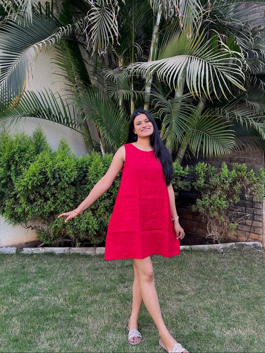 Woman in a red dress standing in front of tropical plants