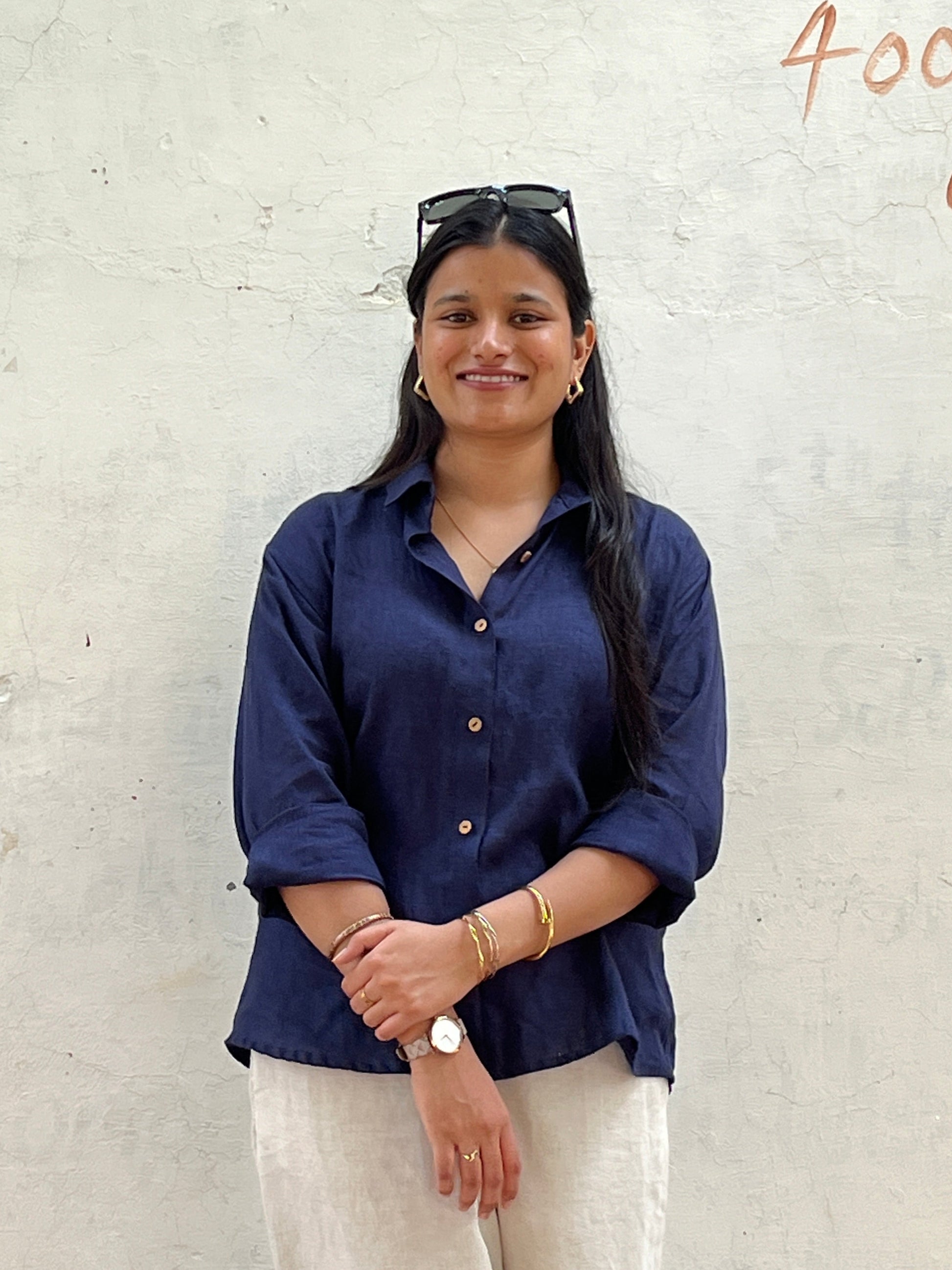 Woman wearing a navy blue shirt on a light grey background
