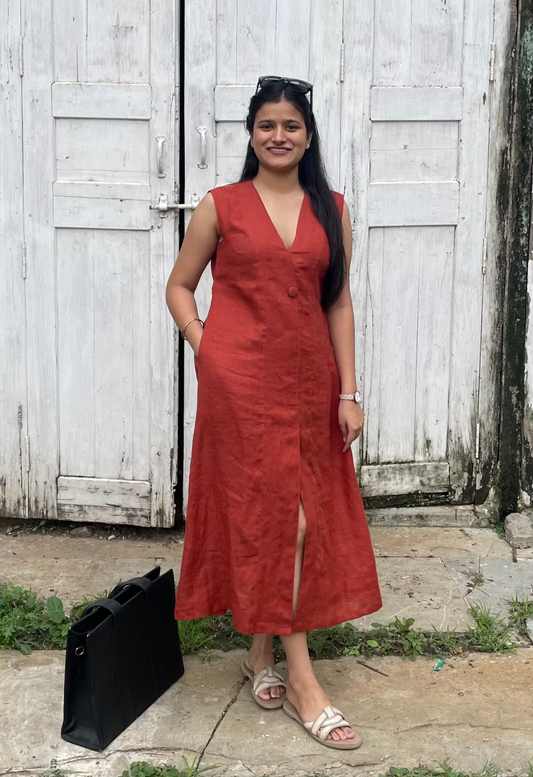 Woman in a red dress standing in front of a white wooden gate